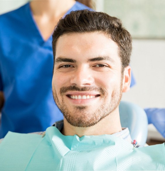 Young man smiling in chair at oral surgery office