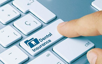 Man pushing button on a keyboard that says dental insurance
