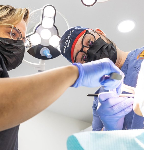 Oral surgeon and assistant performing wisdom tooth extraction